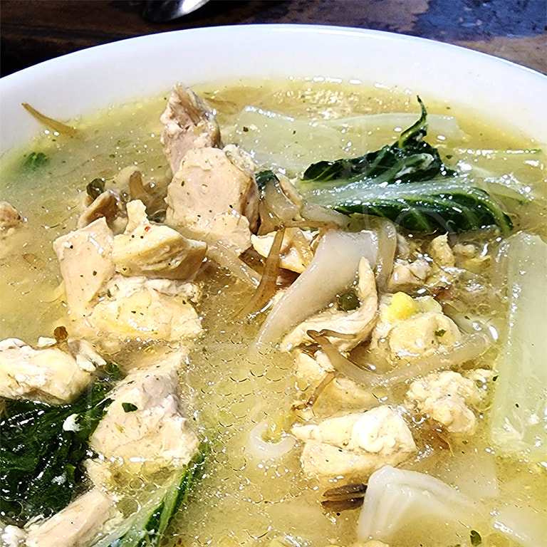 Nam Sai - Traditional chicken soup with rice noodles, bean sprouts & locally grown Asian greens of the day (or with additional shrimp)